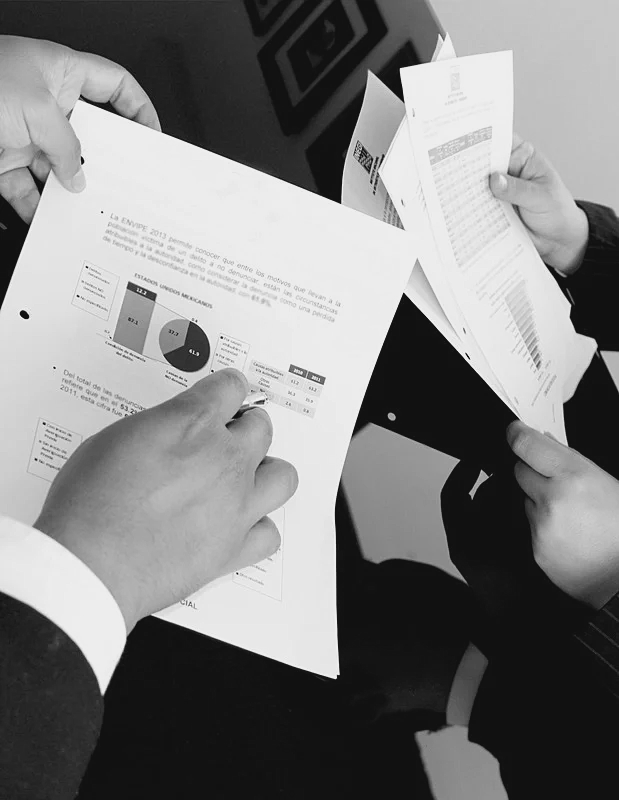 A two people in business attire reviewing documents.